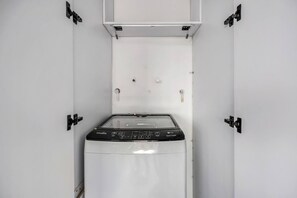 A compact washing machine in a white cabinet with a control panel, located in a small, enclosed space. - Oslo 2101 in Medell n (Medellín)