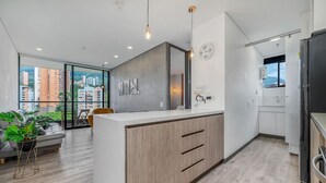Eine moderne Küche mit einer großen Kochinsel, Holzschränken und Blick auf die Stadt.