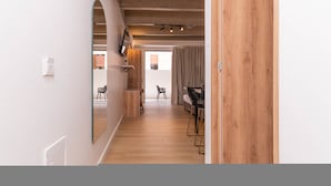 A modern interior with a wooden floor, a dining area with a table and chairs, and a large mirror on the wall. - Opera 501 in Medell n (Medellín)