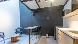 A modern kitchen with a bar area, a round wooden table, and black chairs. - Opera 101 in Medell n (Medellín)