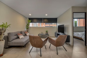 A modern living room with a sofa, two chairs, a TV, and a bed. - Oslo 708 in Medell n (Medellín)