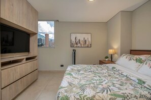 A bedroom with a bed, a TV, a cityscape painting, and a window. - Oslo 2401 in Medell n (Medellín)