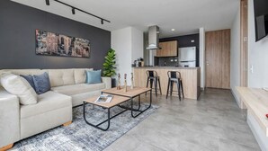 Een moderne woonkamer met een bank, salontafel en kunstwerk aan de muur.