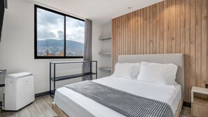 Een moderne hotelkamer met een groot bed, uitzicht op de stad en een houten accentmuur.