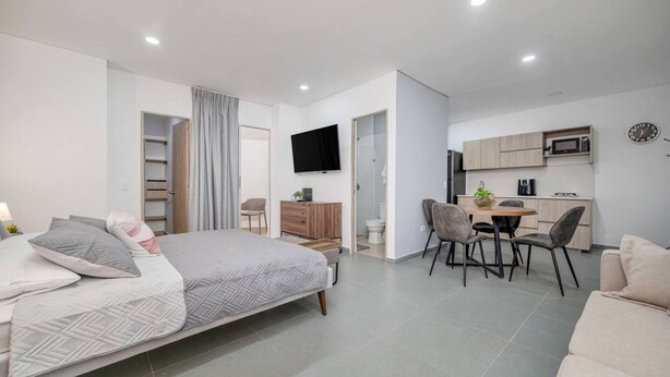 A modern bedroom with a bed, a desk, a chair, and a television. - Oslo 608 in Medell n (Medellín)