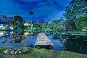 A wooden dock extending into a calm body of water, surrounded by lush greenery and trees. - Espigal 2 in Envigado (Envigado)
