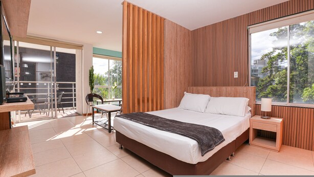 Een moderne slaapkamer met een groot bed, een bureau en een stoel.