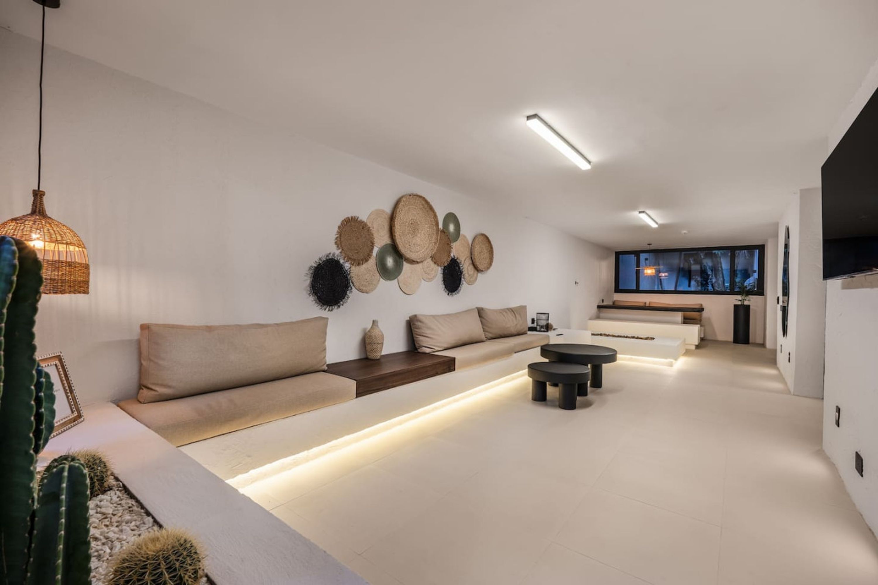 Una sala de estar moderna con un sofá, una mesa de centro y una lámpara fijada a la pared.