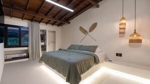 A modern bedroom with a bed, a window, and a ceiling fan. - Luxurious 5BR House in Provenza Perfect for Groups (Medellín)