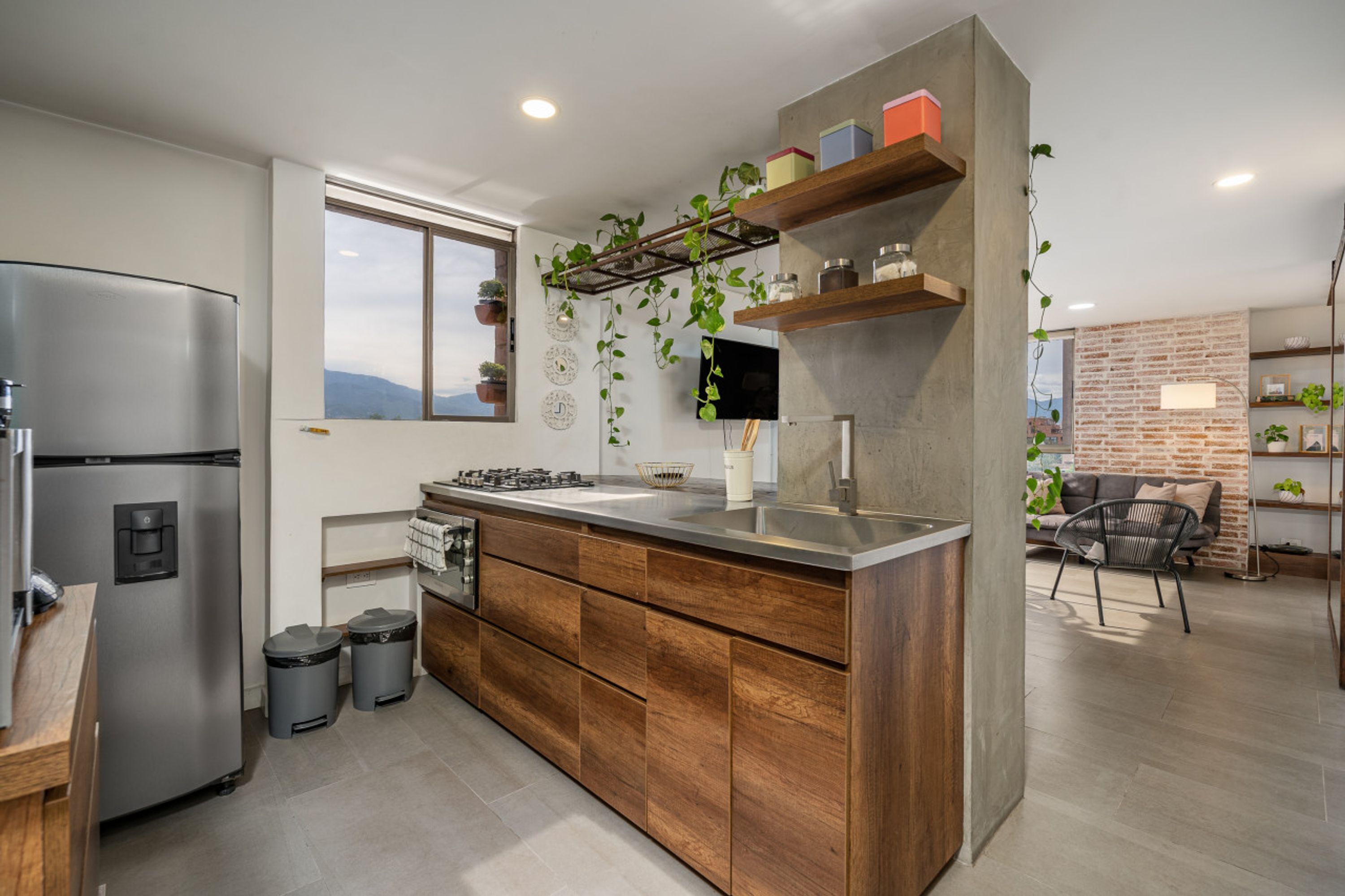 A modern kitchen with a stainless steel refrigerator, wooden cabinets, and a built-in sink.