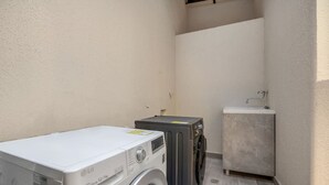 A laundry area with a washing machine, dryer, and a small sink.