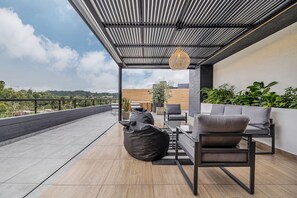 Eine Dachterrasse im modernen Stil mit einer Sitzecke, inklusive Tisch, Stühlen und Sitzsäcken.