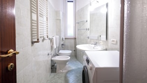 Casa de banho compacta com sanita, bidé e lavatório.