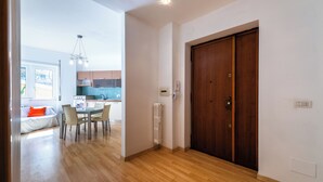 Una cocina moderna con armarios de madera, una zona de comedor con mesa y sillas, y un gran puerta de madera.