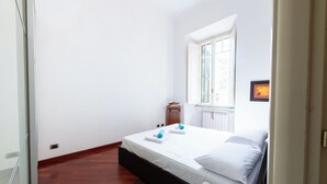 A bedroom with a bed, a window, and a radiator. - Casa Aosta (Rome)