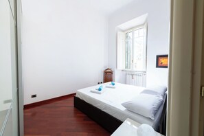 A bedroom with a bed, a window, and a radiator. - Casa Aosta (Rome)