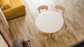 A round table with four wooden chairs in a room with wooden flooring. - Vico Sedil Capuano 21 (Naples)