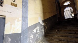 A staircase with peeling paint and a metal gate at the top. - Vico Sedil Capuano 21 (Naples)