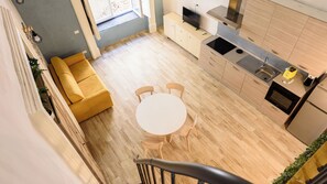 A modern kitchen with a dining area, a sofa, and a staircase. - Vico Sedil Capuano 21 (Naples)