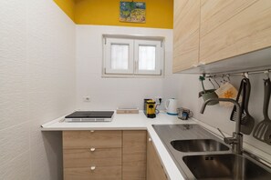 A compact kitchen with a window, a kettle, a tea box, and a coffee maker. - Vico Cangiani al Mercato, 20 (Naples)