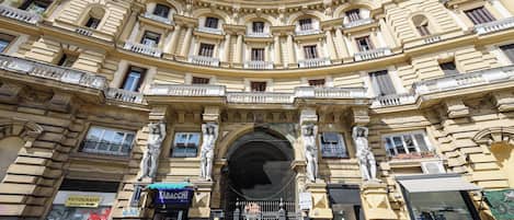 A historic building with ornate architecture, multiple balconies, and a central entrance.