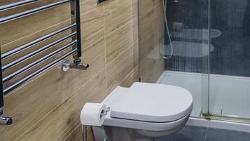 A modern bathroom with a toilet, bidet, and sink.