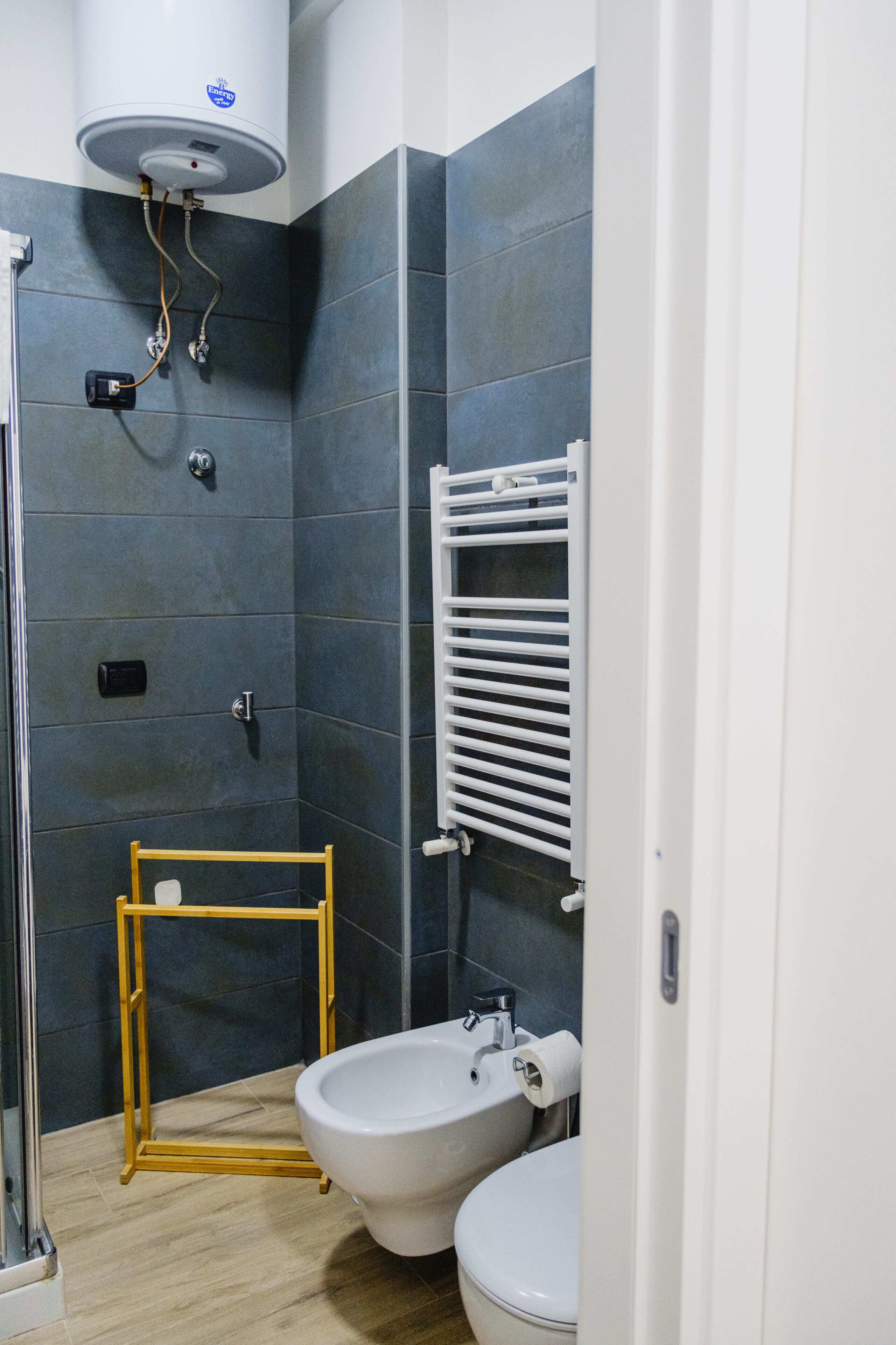 Ein Badezimmer mit Dusche, Toilette, Bidet und Handtuchhalter.