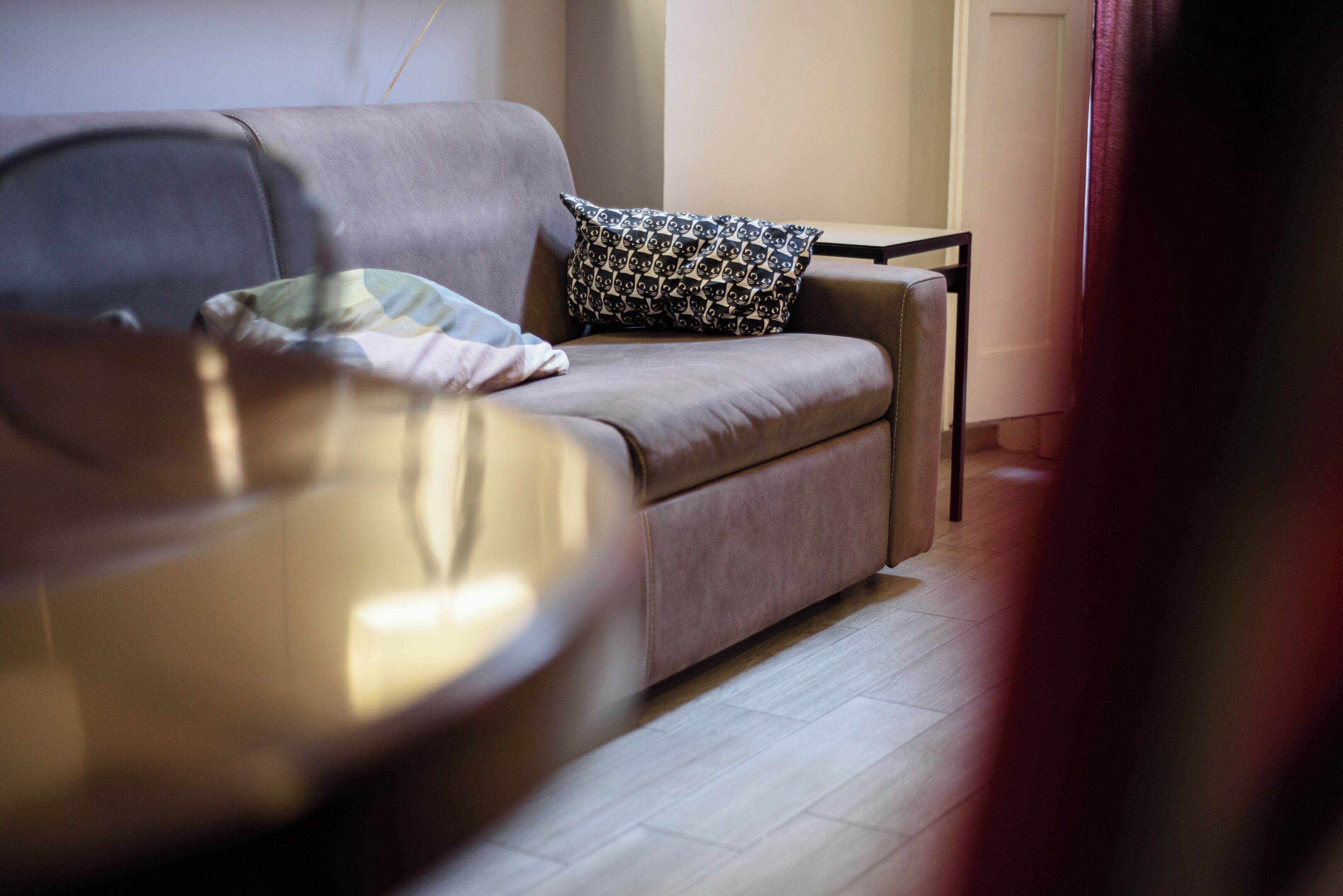 Una sala de estar moderna con un sofá, un cojín estampado y una mesa de centro redonda.
