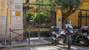 Ein verschlossenes Tor mit einem Motorrad davor.