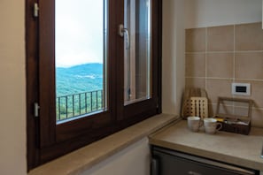 A kitchen with a window, a tea box, and two mugs on the counter. - Tana Dell'orso 20 (Rionero Sannitico)