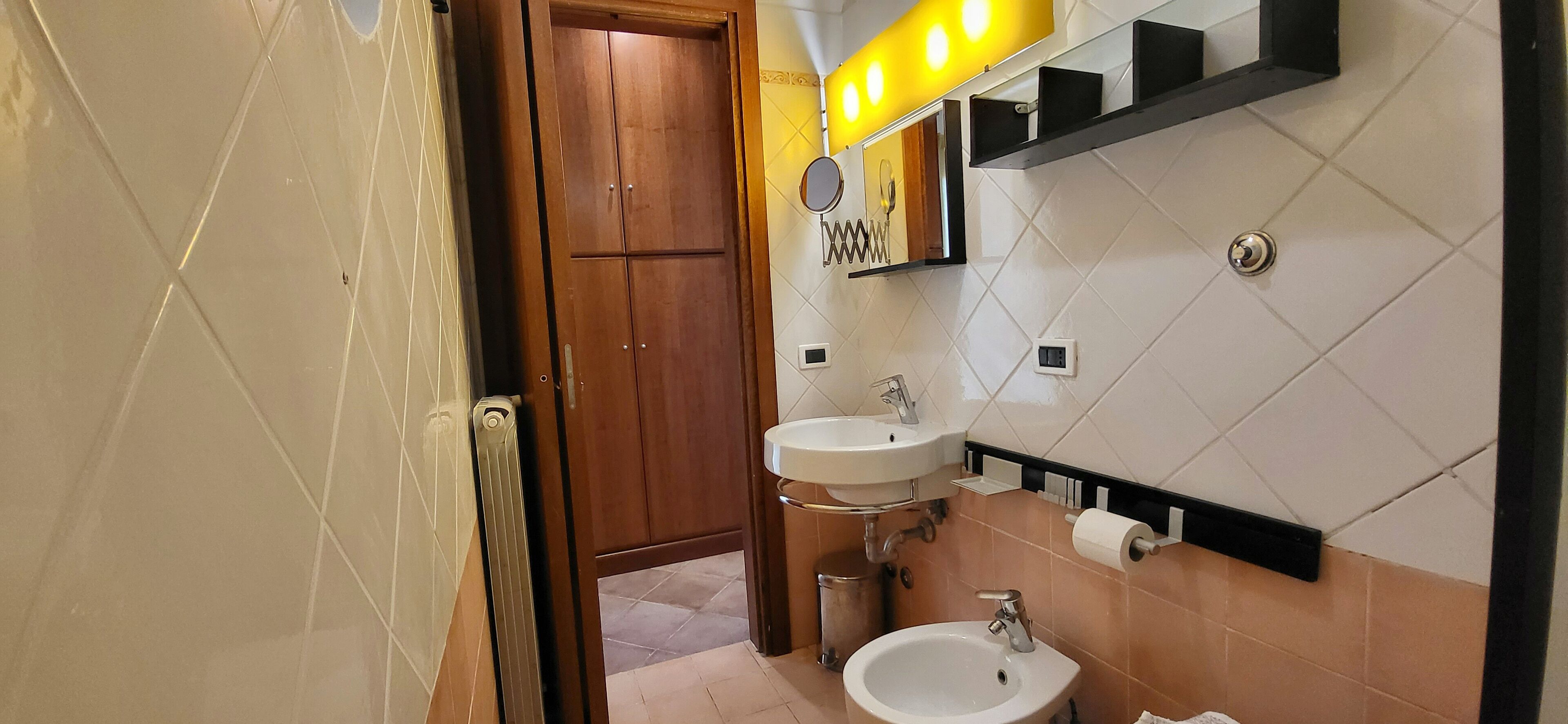 Une salle de bain avec deux lavabos, un miroir et des toilettes.