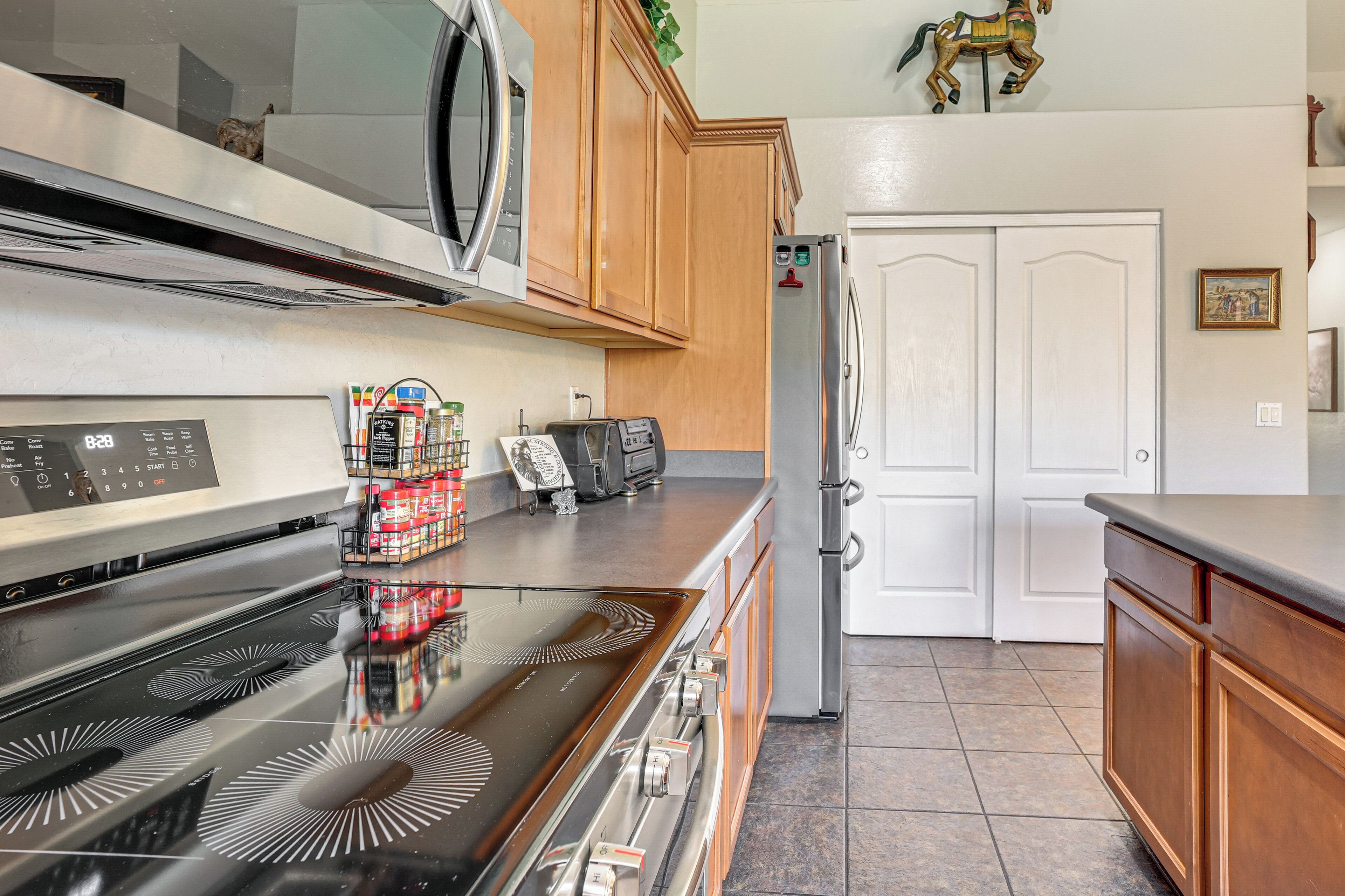 A kitchen with a stove, microwave, cabinets, and a refrigerator.