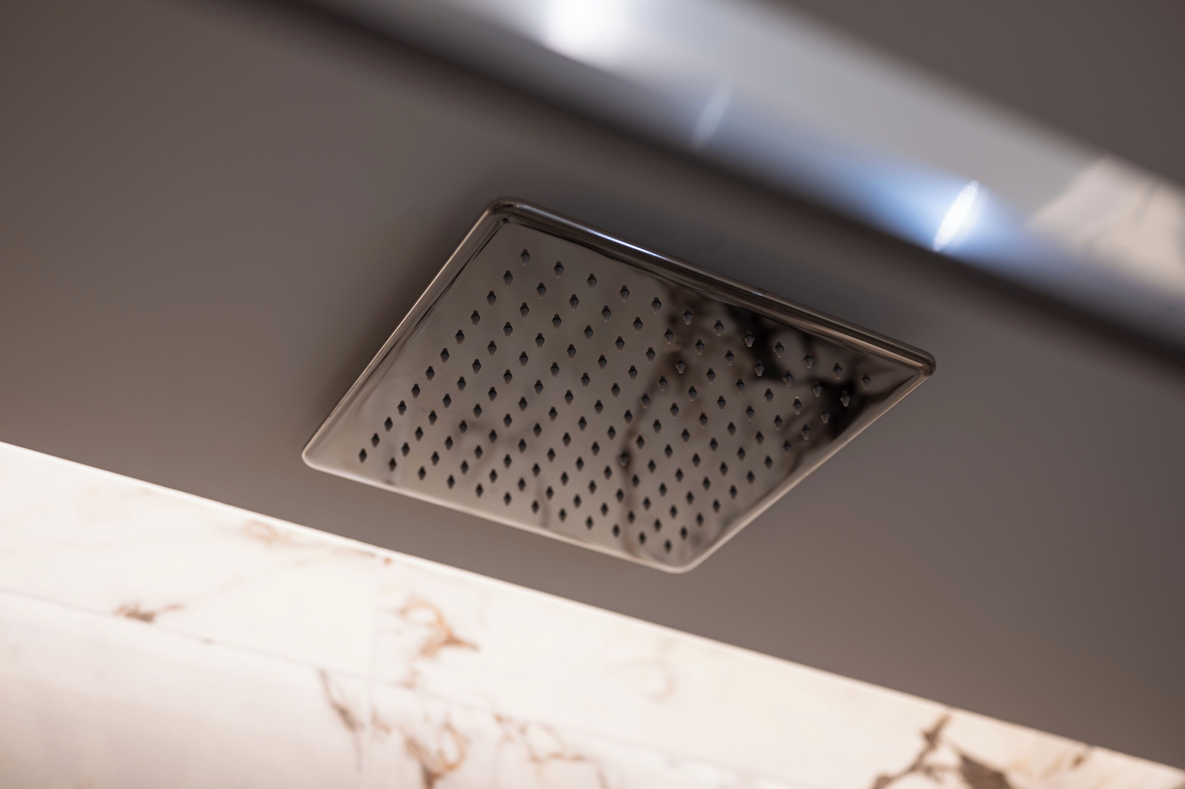 A ceiling vent with a perforated metal grille.