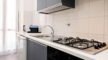 Cozinha moderna com fogão a gás, pia e lava-louças.