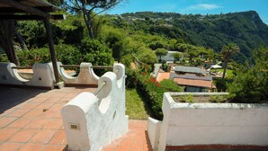 Un espace extérieur aménagé en terrasses, offrant une vue sur un village perché sur une colline.