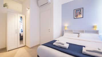 Ein modernes Hotelzimmer mit einem großen Bett, einem Kleiderschrank und einem Bild an der Wand.