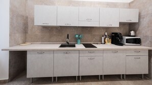 Een moderne keuken met een groot aanrecht, een spoelbak, kastjes en een magnetron.
