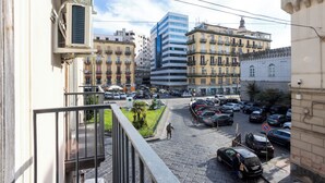 A street view with buildings, parked cars, and a pedestrian. - Palazzo Pepe (Naples)