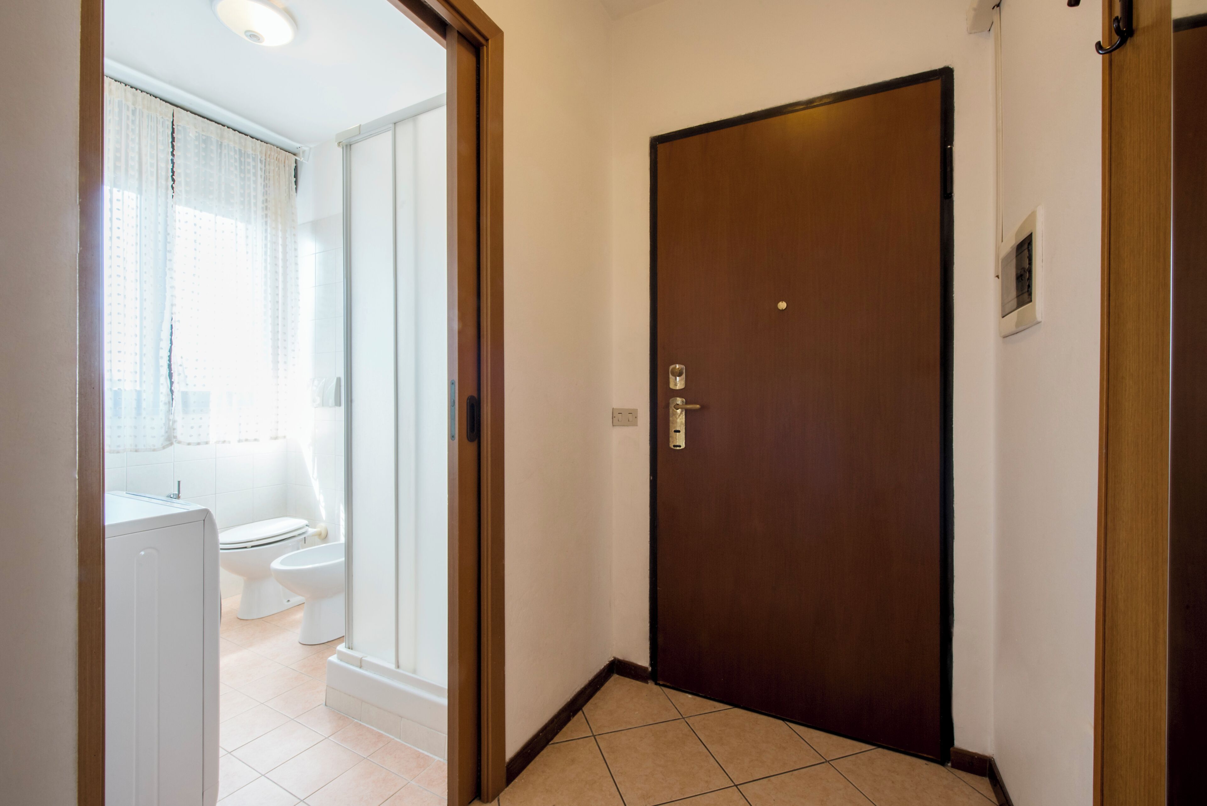 Une salle de bain avec des toilettes, une douche et une porte.