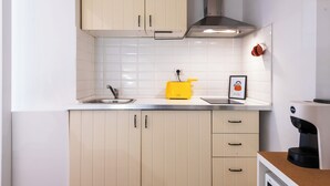 A kitchen with beige cabinets, a yellow toaster, a coffee maker, and a framed picture on the counter. - Archetto by the Vatican (Rome)
