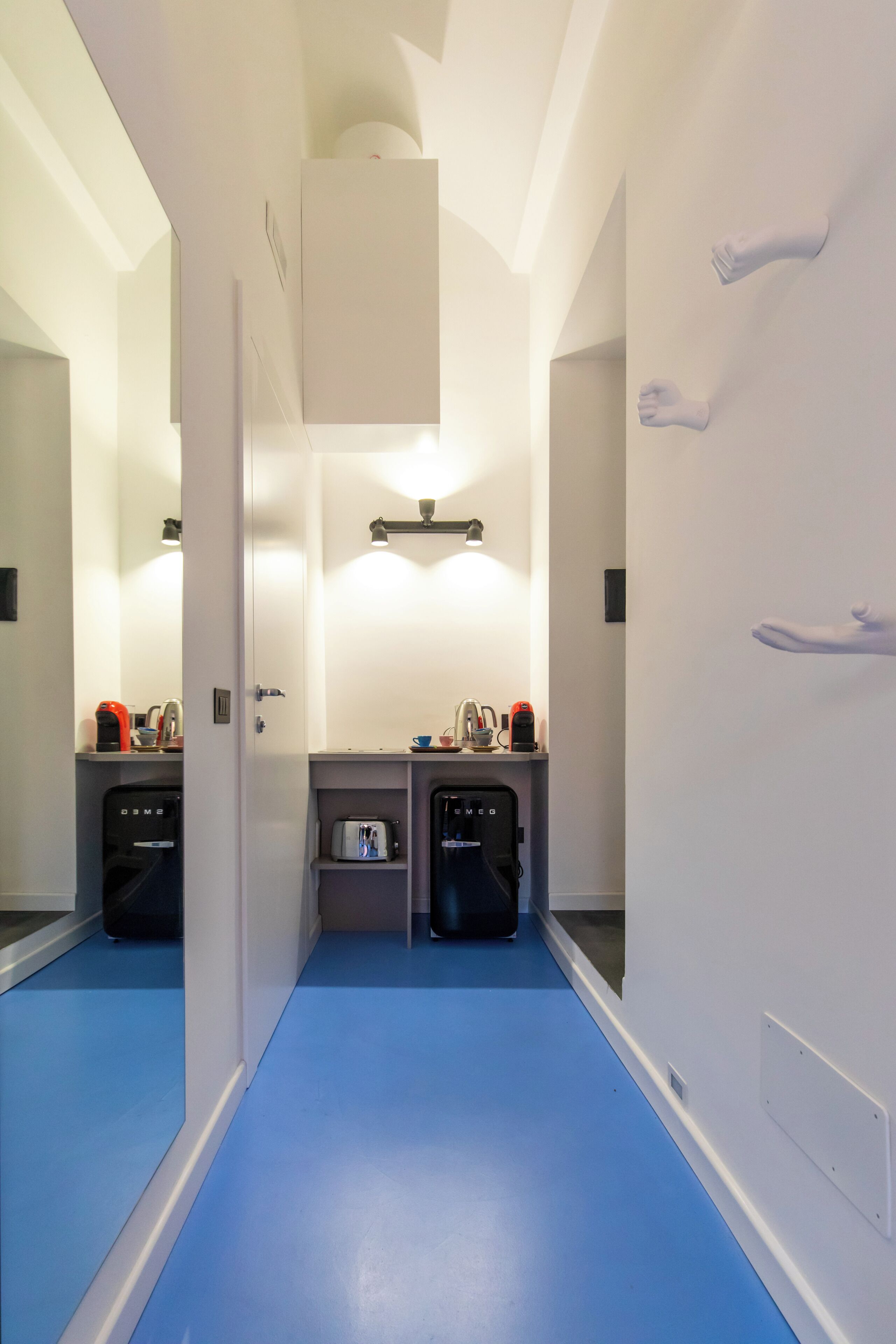 A hotel bathroom with a blue floor, a mirror, a sink, and a towel rack.