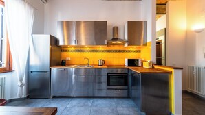 Een moderne keuken met roestvrijstalen apparatuur, een houten aanrecht en een betegelde achterwand.