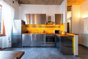 Eine moderne Küche mit Edelstahlgeräten, einer Holz Arbeitsplatte und einer gefliesten Spritzschutzwand.