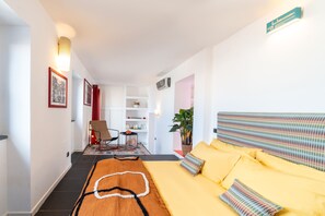 Ein modernes Hotelzimmer mit einem großen Bett, einem kleinen Schreibtisch, einem Stuhl und einer Zimmerpflanze.