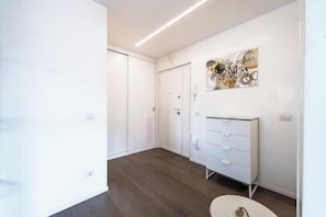 A modern, well-lit hallway with a white wardrobe, a white dresser, and a wall-mounted artwork. - Time 4 Rome (Rome)