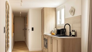 Una cocina moderna con armarios de madera, horno empotrado, lavamanos y ventana.