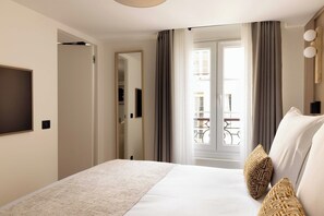 Une chambre d’hôtel avec un lit, une télévision, une porte et une vue sur l’extérieur.