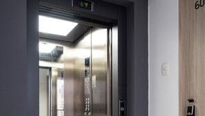 An elevator with a digital display, a wooden door with a lock, and a tiled floor. - Serene 2-bedroom apartment in charming Cusco near historic sites (Cusco)