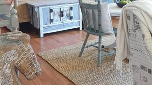 Un dormitorio con una cama con dosel, un escritorio, una silla, una mesita y una planta en maceta.