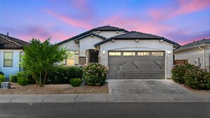 A residential house with a garage, driveway, and landscaped garden. - Game Day Stay - Community Pool Access + Walk to Stadium + Close to Westgate (Glendale)